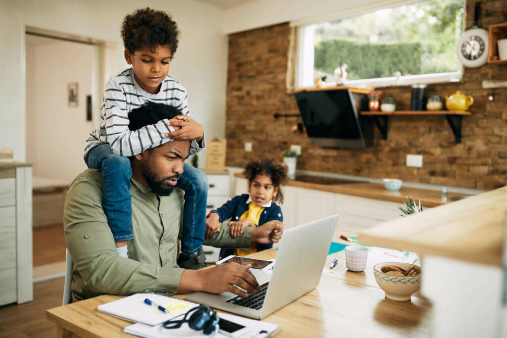 Man being distracted by kids while trying to work from home