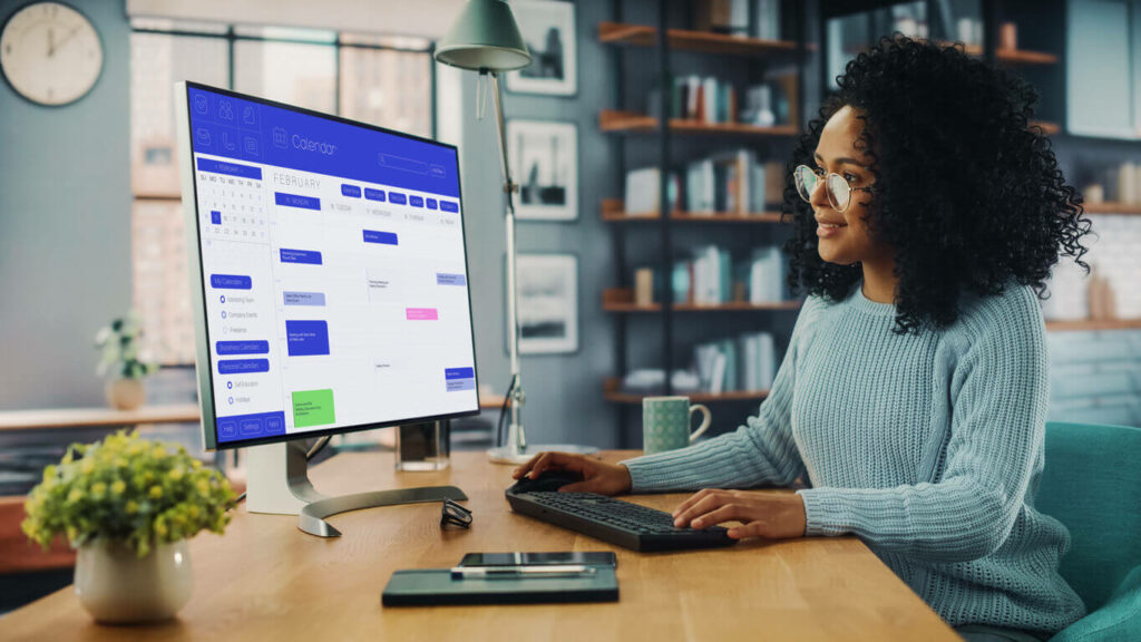 Female checking her calendar on a desktop computer in her living room